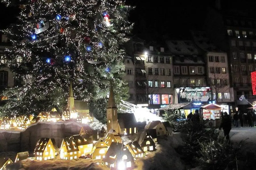 Beleuchteter Weihnachtsmarkt am Abend in Straßburg.